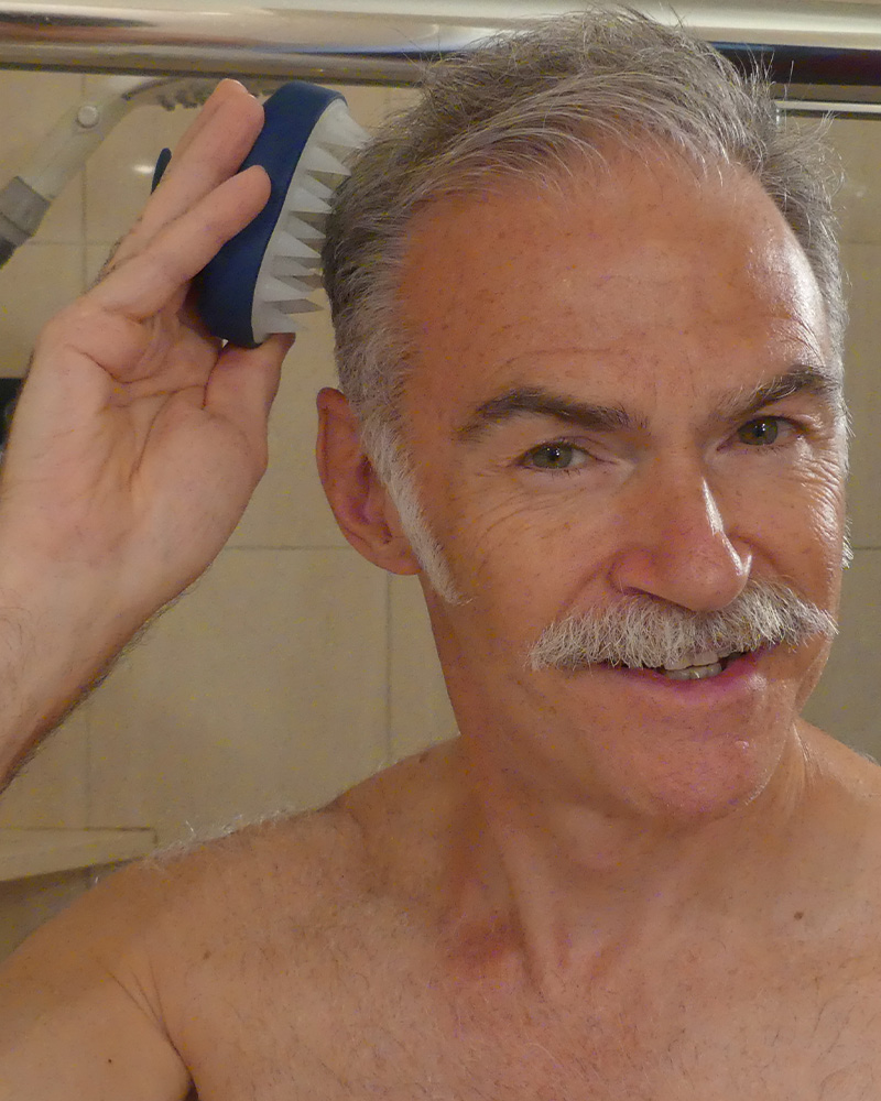 Man brushing hair in bathroom.