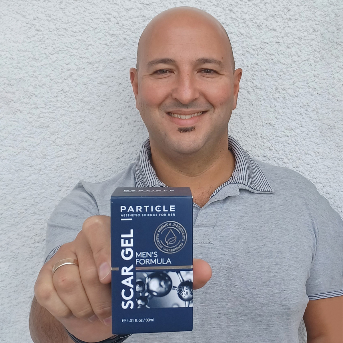 Man holding a Particle product, smiling in close-up.